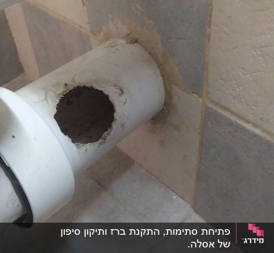 צינור לבן עם חור בקיר אריחים